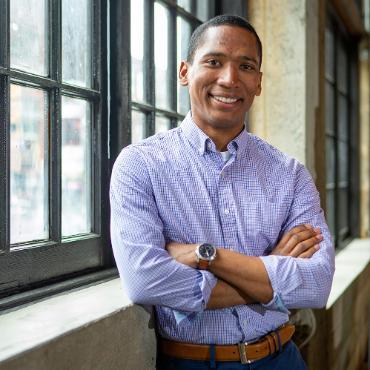 Efrain Hudnell leaning against a wall with a window